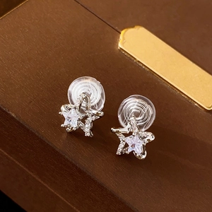Macro shot of silver star-shaped clip-on earrings with zircon on a jewelry box