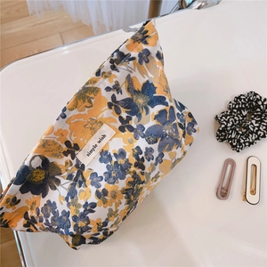 Detail shot of vintage floral makeup bag with simple wish label on yellow fabric