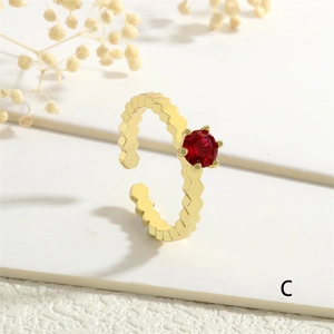 Detail of a vintage adjustable gold ring featuring a red zircon and honeycomb texture