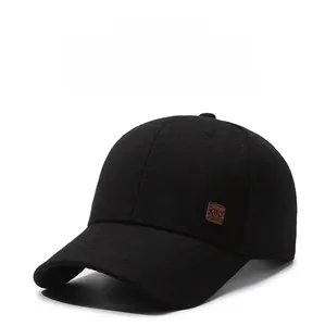 Detail of black baseball cap showing breathable cross-texture fabric and brown leather KWC label