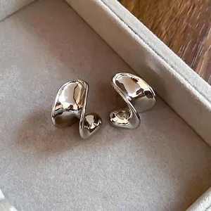 Polished silver C-shaped fluid metal earrings with irregular liquid lava aesthetic design