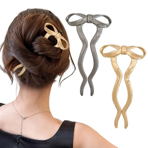 Detail of gold and silver bow hairpins showing twisted metal fork and elegant bun style