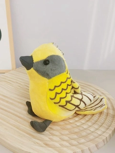 Close-up of yellow plush bird keychain with soft texture on a wavy wooden tray