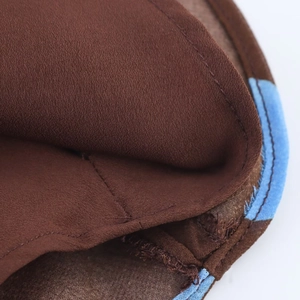 Close-up of brown polka dot fabric with blue piping showing high-quality stitching detail