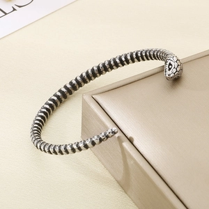 Detailed view of vintage silver snake head bracelet with intricate scale textures