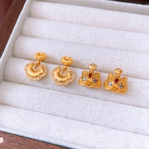 Macro detail of 24k gold-plated fox pendants and Ruyi charms with sparkling crystals