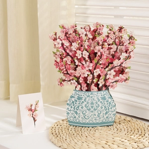 Close-up of a 3D pink cherry blossom paper bouquet in a blue vintage patterned vase