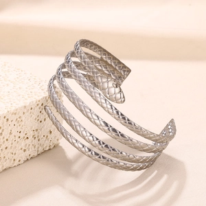 Detail of silver snake-shaped arm cuff with intricate mesh scale texture on metal surface