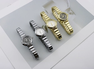 Detail of four quartz watches in gold and silver with Roman numerals and crystal bezel