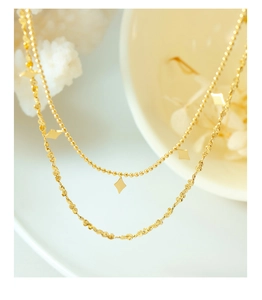 Detail view of double-layered gold choker with geometric diamond pendants and wavy chain links