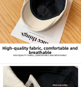 Detail of premium beige fabric newsboy cap showing metal snap button and inner lining