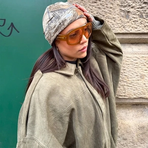 Close-up of Realtree camo knit beanie paired with a khaki pilot jacket and orange glasses