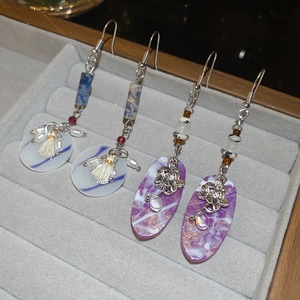 Detailed close-up of handmade ethnic earrings with blue marble patterns and resin pendants