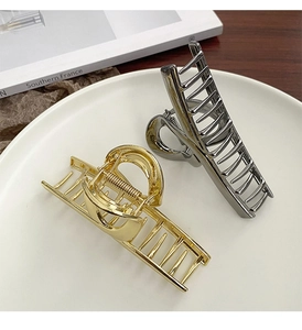 Minimalist large metal hair clips in gold and silver finish on a stylish magazine