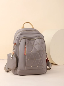 Mochila gris de tela oxford para mujer con remaches, bordado y un pequeño monedero