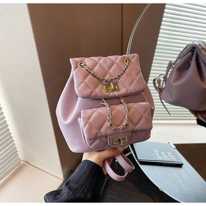 Close-up of quilted lavender backpack featuring golden twist-lock pockets and chain detail