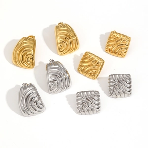 Dettaglio degli orecchini in acciaio inossidabile 18k oro e argento con trama ondulata