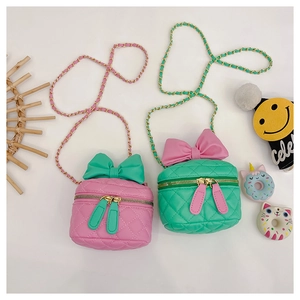 Top view of pink and green quilted crossbody bags for girls with bow details and chain straps