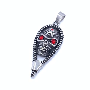 Close-up of vintage skull pendant with three red gems and a unique zipper teeth edge