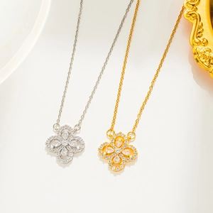 Detail view of gold and silver four-leaf clover necklaces with shimmering zircon inlay