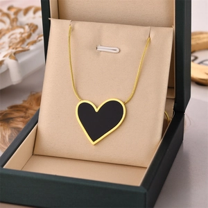 Collier doré avec pendentif cœur noir dans son écrin de luxe, design élégant minimaliste