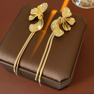 Detail goldene Blumen-Ohrringe mit Quasten und Kristallen auf einer Leder-Schmuckbox