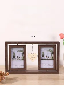 Close-up of double rotating wooden picture frame with heart pendant and glass panels