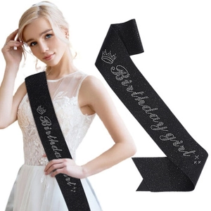 Detail of a black glitter fabric birthday girl sash with sparkling silver lettering