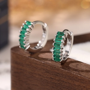 Macro shot of S925 silver hoop earrings with emerald-green step-cut rectangular stones