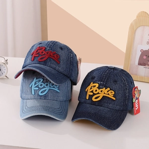 Detailed view of 3D Pogue embroidery on washed denim kids baseball caps in blue tones