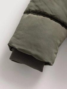 Detail of army green windproof jacket with ribbed cuffs and high-density stitching