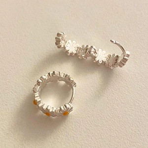 Close-up of S925 sterling silver daisy hoop earrings with yellow center detailing