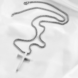 Détail d'un pendentif croix en acier de 45mm sur une chaîne à maillons carrés