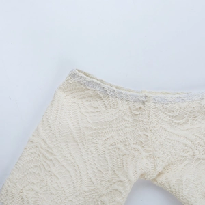 Close-up of off-white dress showing wavy lace texture and detailed knitting fabric