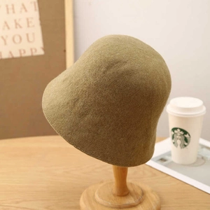 Winter wool felt bucket hat in olive green shown on a wooden stand for women
