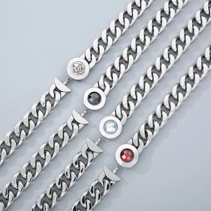 Detail of four silver Cuban chains with skull, black, clear and red gemstone clasps