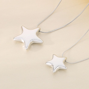 Detail of silver hollow pentagram pendants on a sleek snake chain necklace