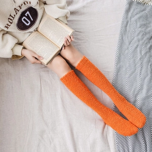Soft orange coral fleece knee high socks for women providing warmth in winter