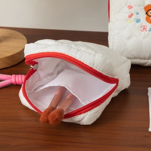 Trousse à cosmétiques brodée matelassée blanche avec fermeture éclair rouge et poche