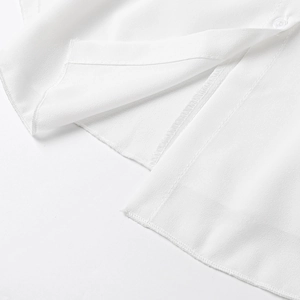 Detail view of the hem stitching and side slit on this lightweight white chiffon blouse