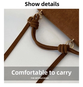 Detail view of brown matte suede bag featuring knotted rope handle and gold metal ring hook