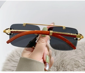 Detailed close-up of retro square aviator glasses with gold metal C-decor and wood temples