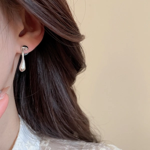 Polished silver liquid metal teardrop earrings on model for a trendy look