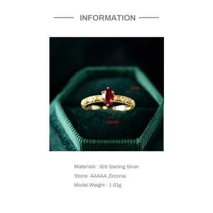 Macro shot of S925 sterling silver oval red ruby ring in a green velvet jewelry box