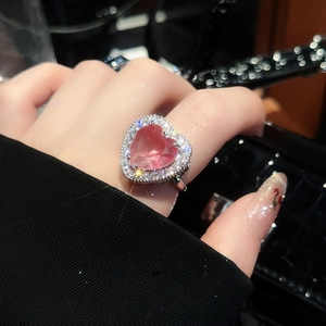 Close-up of heart-shaped pink zircon ring with pavé setting on a silver-tone band