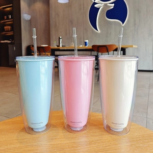 Three 750ml double-layer straw cups in blue, pink, and beige on a wooden table