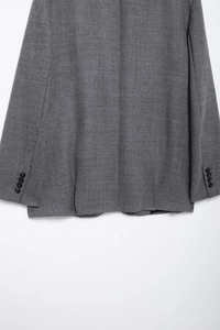 Detail of grey blazer showing woven fabric texture and four-button cuff decoration