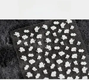 Macro shot of 5D white floral nail stickers featuring embossed flower designs