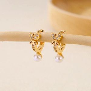 Elegant gold butterfly hoop earrings with dangling white pearls and crystal accents