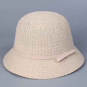 Detail of knitted fisherman hat showing beige textured weave and delicate bow ribbon